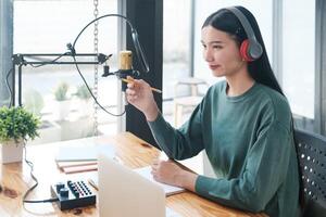 un' donna è seduta a un' scrivania con un' il computer portatile e un' penna foto