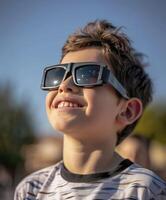 un' giovane ragazzo indossare protettivo bicchieri è Guardando il solare eclisse. foto