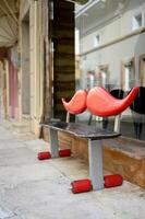 chio, Grecia dicembre 07 2023. creativo panchina fatto di skateboard con grande legna rosso baffi elementi nel hippy stile. moderno urbano strada arredamento. con no le persone. verticale foto. foto