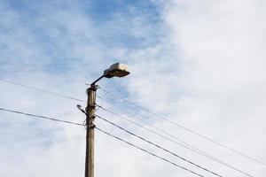 vecchia lanterna della città su uno sfondo di cielo e nuvole durante il giorno foto