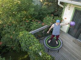 anziano uomo è esercizio su un' mini trampolino foto