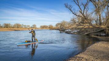 spedizione stile inverno In piedi su paddling su il Sud platte fiume nel orientale Colorado foto