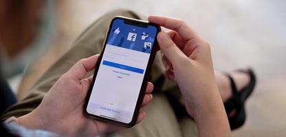 donna che tiene un iphone x con servizio internet sociale facebook sullo schermo. foto