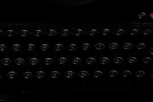 dettaglio di antica macchina da scrivere su sfondo nero foto