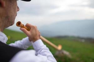 particolare di un suonatore di corno alpino. sulle alpi foto