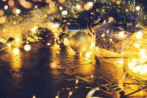 regalo di natale con nastro azzurro e palle di decorazione natalizia su sfondo nero bokeh astratto con spazio copia e luci a led decorative. buon natale e anno nuovo. foto