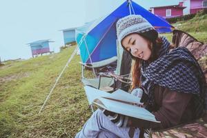 il viaggio della donna asiatica si rilassa durante la vacanza. campeggio in montagna. sedersi scrivere una nota sulla sedia. Tailandia