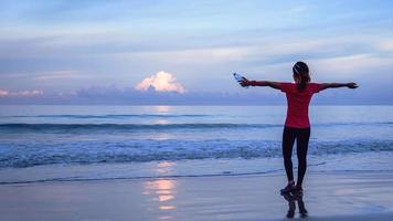 ragazza in esecuzione allenamento jogging sulla spiaggia al mattino. rilassati e felici di correre sul mare. in estate foto