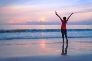 ragazza in esecuzione allenamento jogging sulla spiaggia al mattino. rilassati e felici di correre sul mare. in estate foto