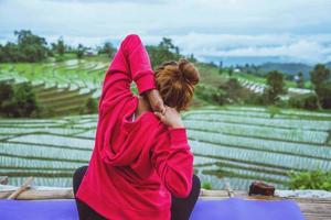 donna asiatica rilassarsi in vacanza. gioca se lo yoga. sul balcone paesaggio campo naturale.papongpieng in thailandia