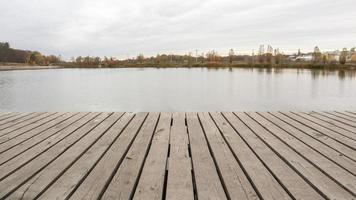 un piccolo molo di legno su un tranquillo lago nella nebbiosa mattina d'autunno.