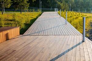 un' pedone strada fatto di tavole, un' sentiero per a piedi nel il parco, un eco pista nel il campagna, cura per il ambiente, di legno decking su il terra. foto