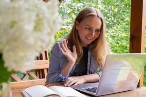 giovane donna libero professionista Lavorando in linea utilizzando il computer portatile e godendo il bellissimo natura all'aperto nel giardino. in linea incontro formazione scolastica. lavoro, opera a partire dal vacanza, ibrido opera modello foto