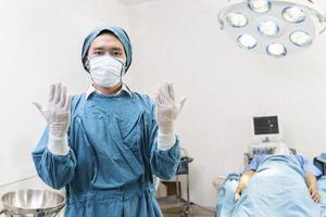medico che indossa guanti che si preparano prima dell'intervento in sala operatoria foto