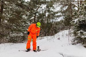 lo snowboarder controlla la sua attrezzatura foto