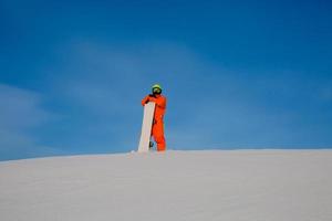 snowboarder freerider con snowboard bianco in piedi in cima alla pista da sci foto