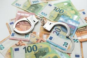polizia manette bugie su un' impostato di verde monetario denominazioni di 100 euro. un' lotto di i soldi le forme un infinito mucchio foto