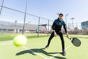 uomo giocando padel nel un' verde erba padel Tribunale interno dietro a il netto foto