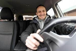 uomo di stile e stato. bello giovane uomo nel pieno completo da uomo sorridente mentre guida un' auto foto