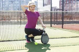 attivo giovane donna provando per battere il palla di padel racchetta mentre giocando tennis nel il Tribunale foto