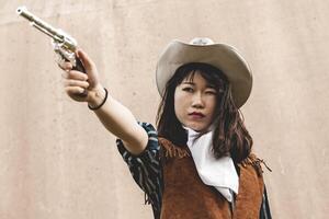 ritratto di un' bellissimo Cinese femmina cowgirl tiro con un' pistola foto