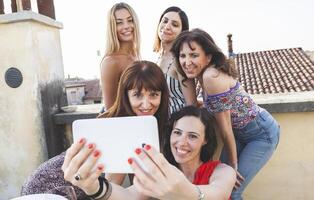 gruppo di femmina amici assunzione un' autoscatto con smarthphone foto