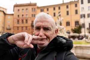 contento mezzo anziano uomo su vacanza assunzione un' autoscatto nel davanti di il Fontana nel piazza navona nel Roma foto