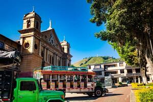 colorato tradizionale rurale autobus a partire dal Colombia chiamato chiva a il centrale piazza di il piccolo cittadina di pacora nel Colombia foto