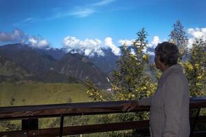 anziano donna turista guardare a il sorprendente paesaggi di il centrale intervalli su il salita per il alto di lettere fra il città di fresno e manizales nel Colombia foto