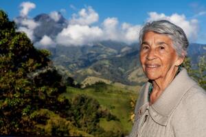 anziano donna turista guardare a il sorprendente paesaggi di il centrale intervalli su il salita per il alto di lettere fra il città di fresno e manizales nel Colombia foto