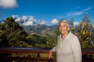 anziano donna turista guardare a il sorprendente paesaggi di il centrale intervalli su il salita per il alto di lettere fra il città di fresno e manizales nel Colombia foto