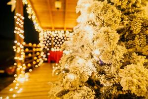 innevato Natale albero con luminosa bianca luci situato all'aperto vicino un' costruzione, un' accogliente festivo momento. foto