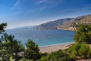 acqua di mare superficie Visualizza orizzonte e il verde pino alberi con il montagne Visualizza su sfondo, Grecia Paradiso isola chios spiaggia foto