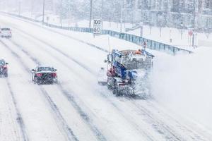 spazzaneve che rimuove la neve dall'autostrada durante una tempesta di neve