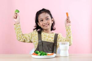 asiatico bambini godendo carota e broccoli verdura per prima colazione foto