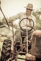 giovane agricoltore su un trattore d'epoca foto
