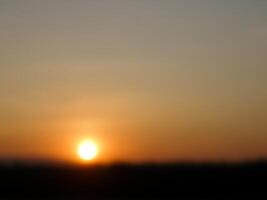 spettacolare tramonto Sopra, arancia sole crescente su al di sopra di il orizzonte foto