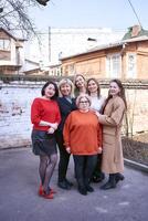 un' squadra di donne Lavorando insieme al di fuori il ufficio su un' primavera giorno foto