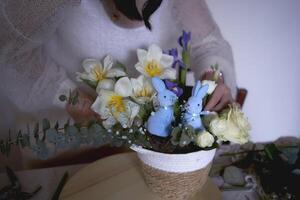 femmina fioraio rendere decorazioni e floreale accordi per Pasqua foto