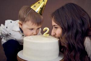 molto emotivo mamma e sua poco compleanno ragazzo mangiare torta foto