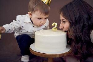 molto emotivo mamma e sua poco compleanno ragazzo mangiare torta foto