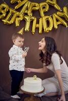 molto emotivo mamma e sua poco compleanno ragazzo mangiare torta foto