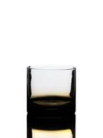 bicchiere da whisky dorato vuoto e riflesso isolato su bianco