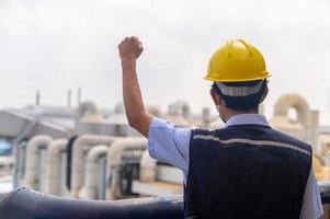 ingegnere in piedi sul tetto dell'edificio di produzione mostra impegno e successo foto