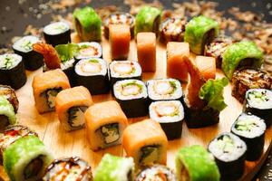 abbondante di legno piatto di Sushi rotoli foto