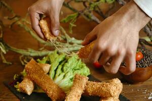 persona taglio su cibo su nero piatto foto