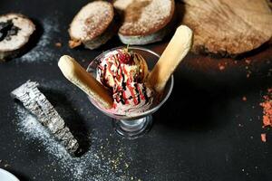 decadente ghiaccio crema coppa di gelato guarnita con cioccolato e fragole foto