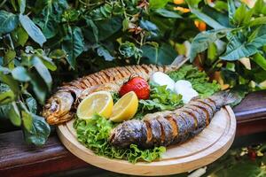 grigliato pesce piatto con Limone e fragola contorno foto