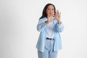 asiatico donna indossare casuale blu camicia è Esprimere a gesti spaventato gesto con mani e copertura sua viso, isolato bianca sfondo foto