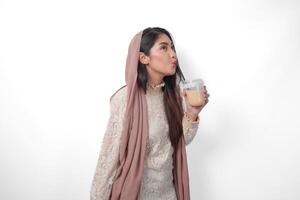 ritratto di asiatico musulmano donna nel foulard velo hijab sensazione assetato dopo digiuno e potabile caffè nel un' plastica tazza. Ramadan concetto foto